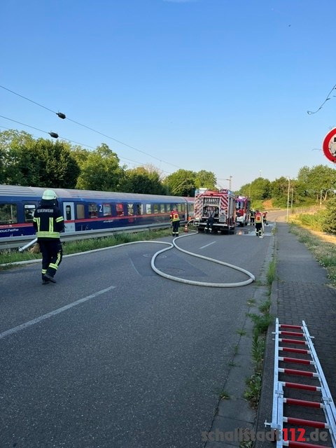 Einsatzfahrzeuge und Zug bei einem Schienenfahrzeugbrand