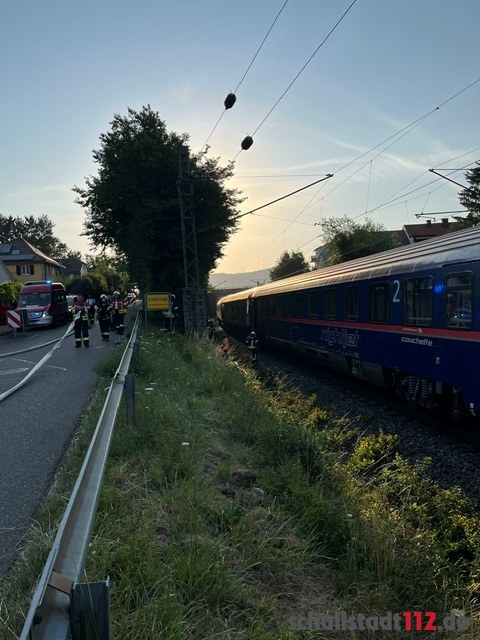 Stillstehender Zug und Einsatzkräfte entlang der Bahnstrecke