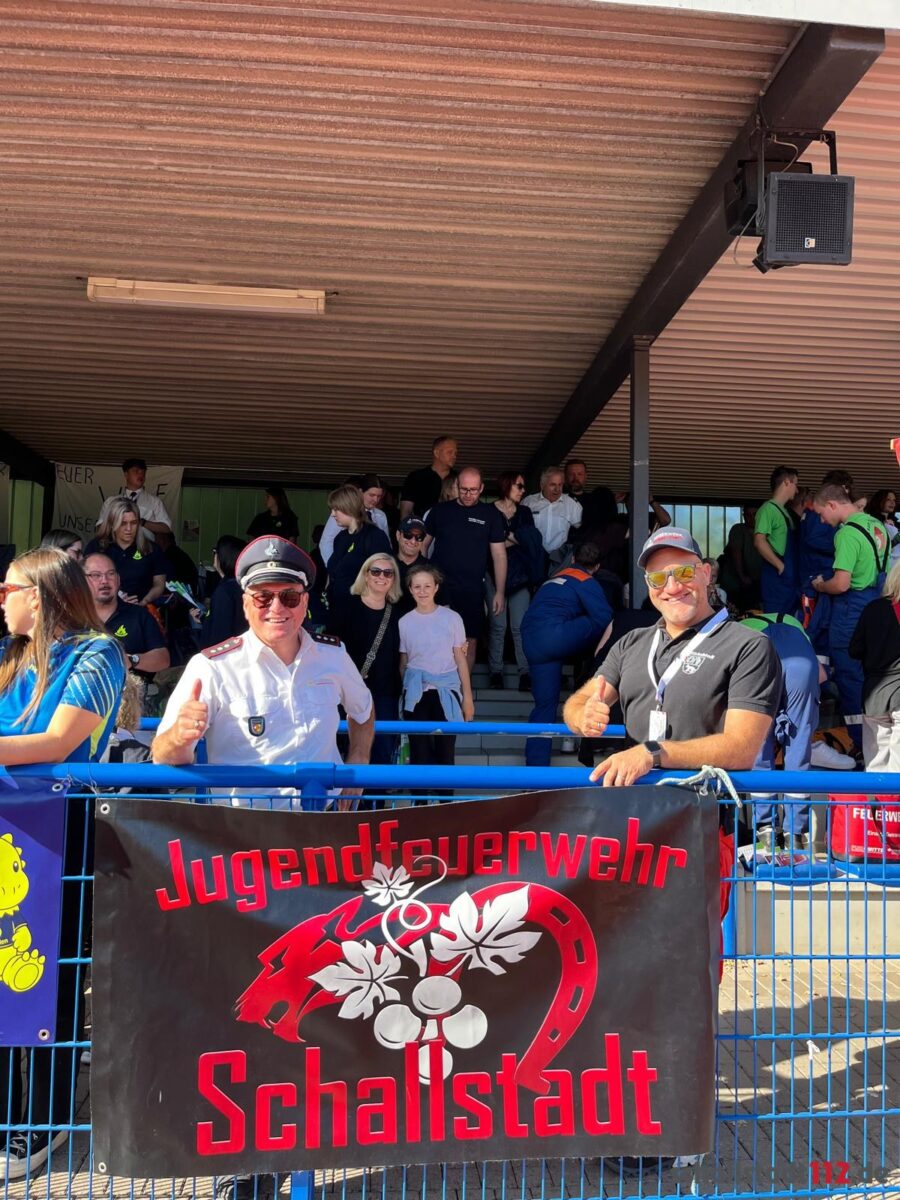 Zwei Unterstützer hinter dem Banner der Jugendfeuerwehr Schallstadt